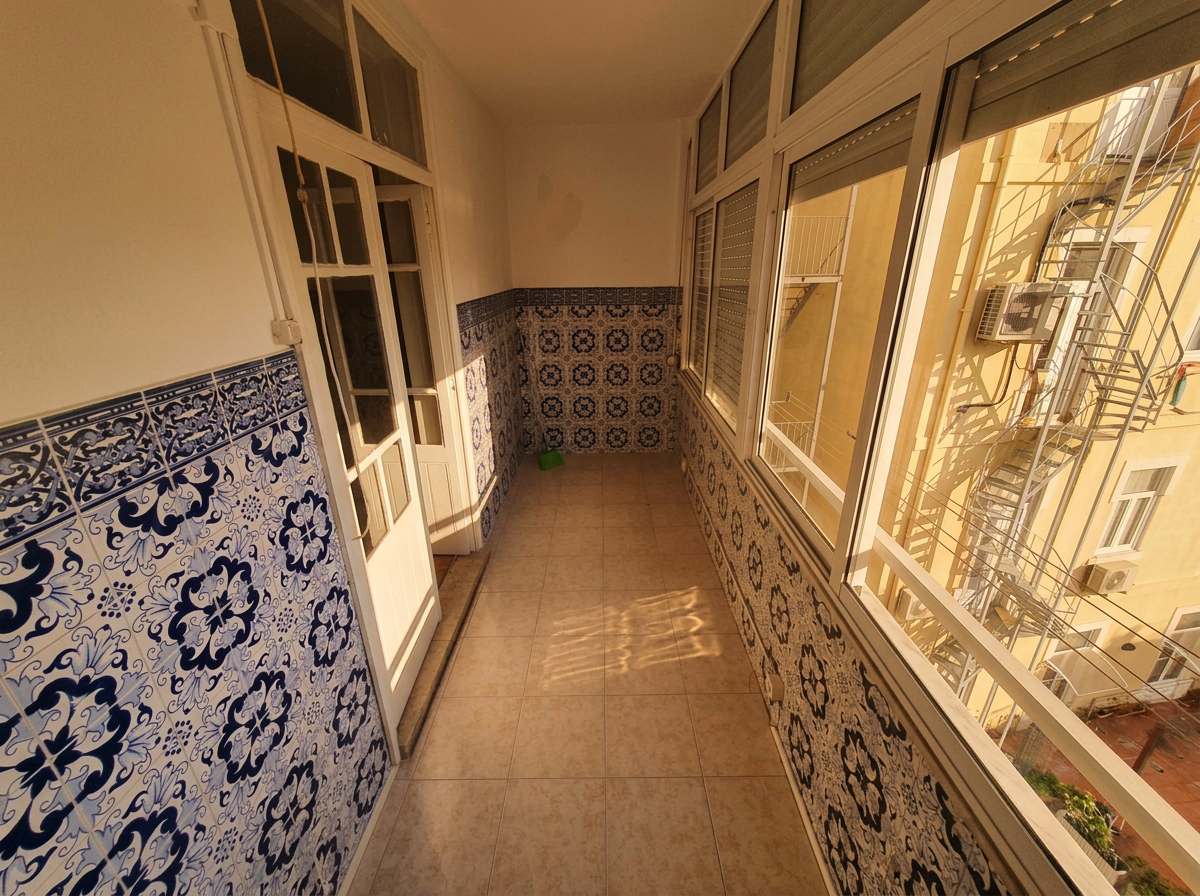 Enclosed veranda lined with original blue azulejos in warm afternoon light